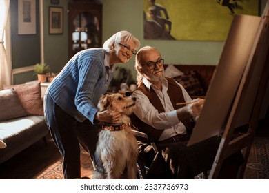 Senior couple painting together with their dog in cozy living room - Powered by Shutterstock