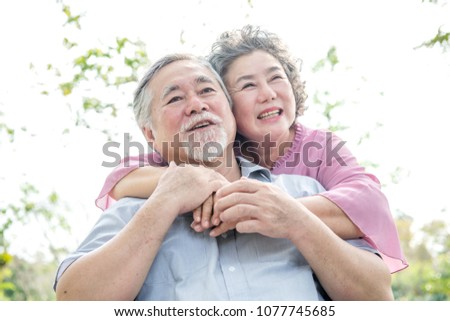 Senior couple in park portrait. Chinese old couple in park, relaxing, smiling.