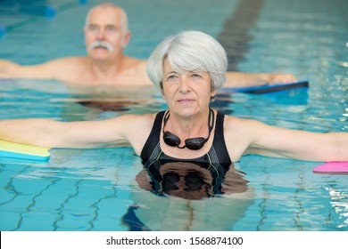 Senior Couple Participating In Aquatic Exercise Class