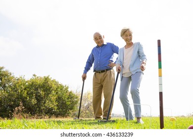 Senior Couple Playing Croquet In Park