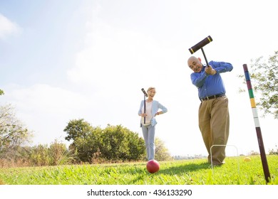 Senior Couple Playing Croquet In Park