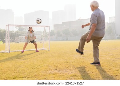 Senior couple playing football in ground and having fun.