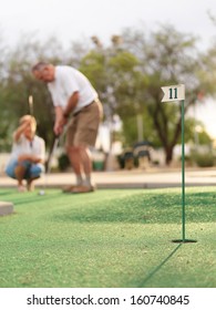 Senior Couple Playing Mini Golf