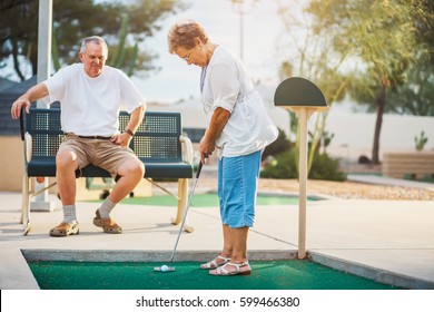 Senior Couple Playing Miniature Golf