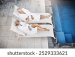 Senior couple, pool and toast champagne for celebration, care or love at luxury resort on vacation. Mature man, woman and outdoor by water in robes for drinks, cheers or wine glass at lodge in Greece