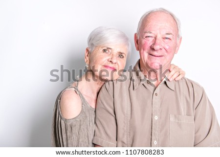 Senior couple posing on studio white background