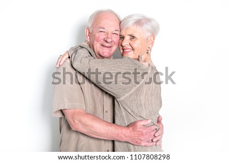 Senior couple posing on studio white background