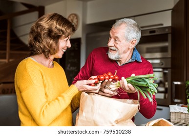 Senior couple preparing food in the kitchen. - Powered by Shutterstock