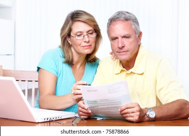 Senior couple reading the bills at new home.