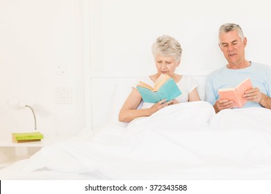 Senior Couple Reading Books At Bed