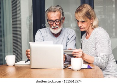 Senior couple reading documents and calculating bills to pay in living room at home.Retirement couple and loan bankruptcy money concept - Powered by Shutterstock