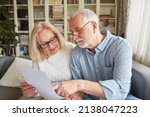 Senior couple reading a retirement plan or power of attorney or living will