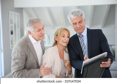 Senior Couple With Real-estate Agent Visiting House For Sale