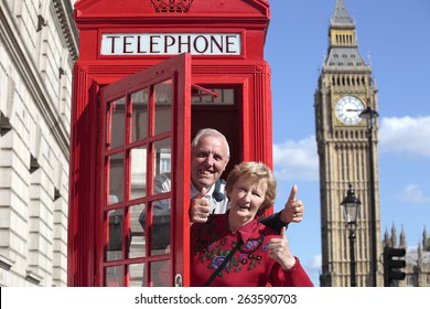 Senior couple with red telephone box in London. Big Ben in the background.