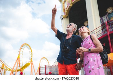 Senior couple relaxing at an amusement theme park, concept of happy and hangout carnival, grandmother and grandfather - Powered by Shutterstock