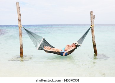 Senior Couple Relaxing In Beach Hammock