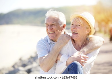 Senior couple relaxing by the sea on sunny day - Shutterstock ID 623697488