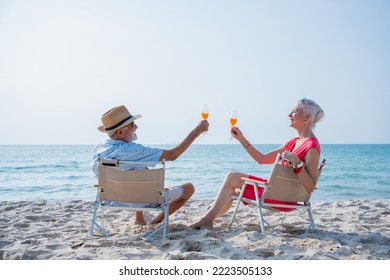 Senior couple relaxing and drink orange juice at tropical beach., Healthy seniors lifestyle concept. - Powered by Shutterstock