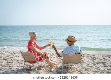 Senior couple relaxing and drink orange juice on sea beach,Summer vacation,Travel and vacation on beach. - Powered by Shutterstock