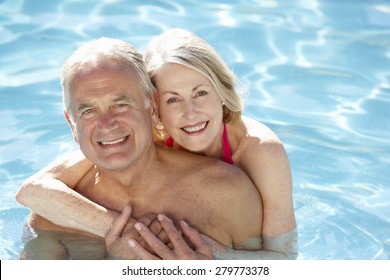 Senior Couple Relaxing In Swimming Pool Together