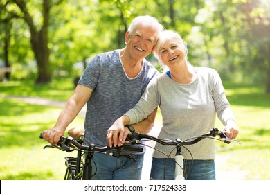 Senior Couple Riding Bikes In Park
