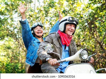 Senior Couple Riding A Classic Scooter