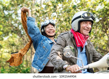 Senior Couple Riding A Classic Scooter