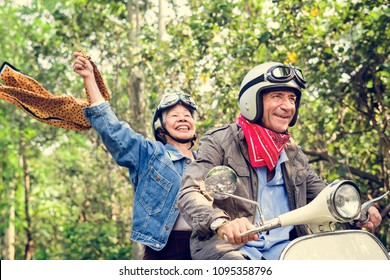 Senior Couple Riding A Classic Scooter