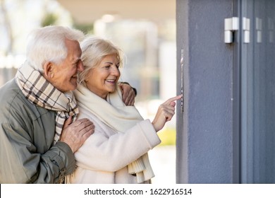 Senior Couple Ringing The Doorbell To Their Guest House
