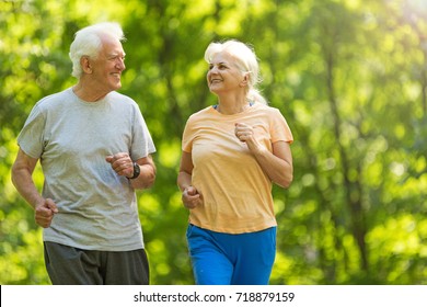 Senior couple running in park
