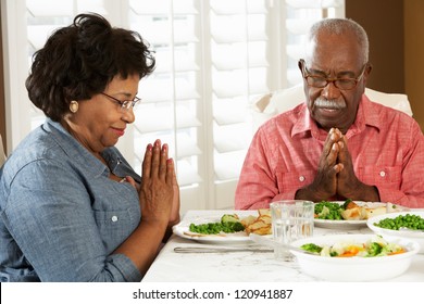 Senior Couple Saying Grace Before Meal At Home - Powered by Shutterstock