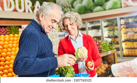 Senior couple shopping for vegetables in the vegetable section in the supermarket - Powered by Shutterstock