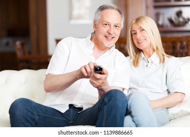     Senior couple sitting in couch and watching tv  - Shutterstock ID 1139886665