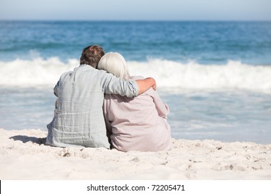 Senior Couple Sitting On The Beach