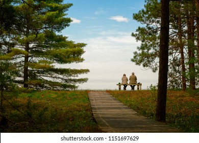 A senior couple sitting on a bench next to Lake Superior - Powered by Shutterstock