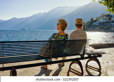 Senior Couple sitting on the bench at the embankment of Ascona luxurious resort on Lake Maggiore, Ticino canton of Switzerland. - Powered by Shutterstock