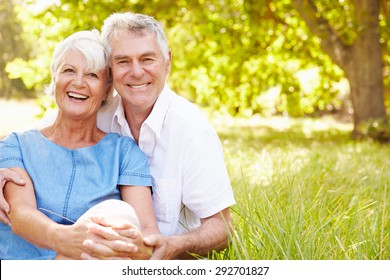 Senior couple sitting on grass together relaxing