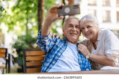 Senior couple sitting at a table in a cafe and using mobile phone
 - Powered by Shutterstock