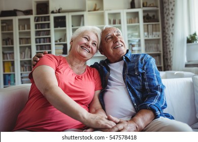 Senior Couple Sitting Together On Sofa At Home