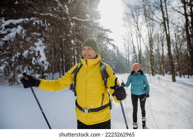 Senior couple skiing together in the middle of forest - Powered by Shutterstock