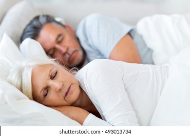 Senior Couple Sleeping In Bed
