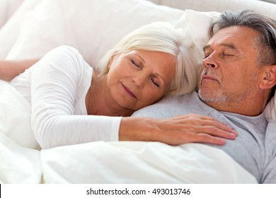 Senior couple sleeping in bed
