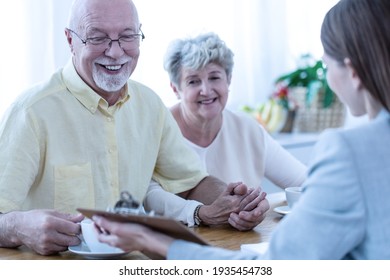 Senior couple smiling and talking to conveyancer 