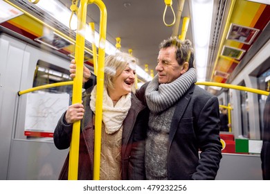 Senior Couple Standing In A Crowded Subway Train