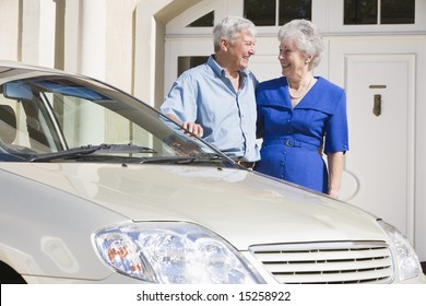 Senior Couple Standing Next To Car Outside House