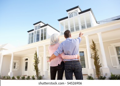 Senior Couple Standing Outside Dream Home