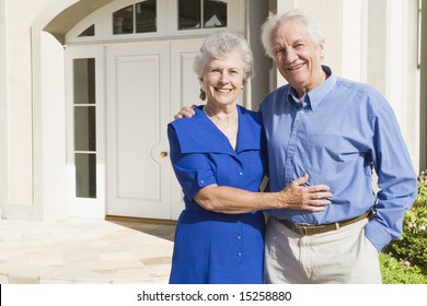 Senior Couple Standing Outside House