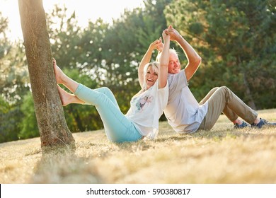 Senior Couple In Summer Laughing In The Park In Summer