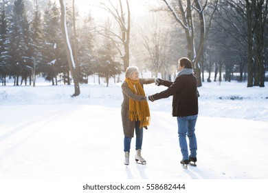 Senior Couple In Sunny Winter Nature Ice Skating.