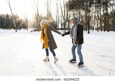 Senior Couple In Sunny Winter Nature Ice Skating.